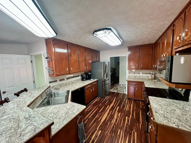 75 Briar Patch Dr, Covington, GA 30014 - kitchen with dark wood-type flooring, a kitchen breakfast bar, sink, a textured ceiling, and stainless steel appliances