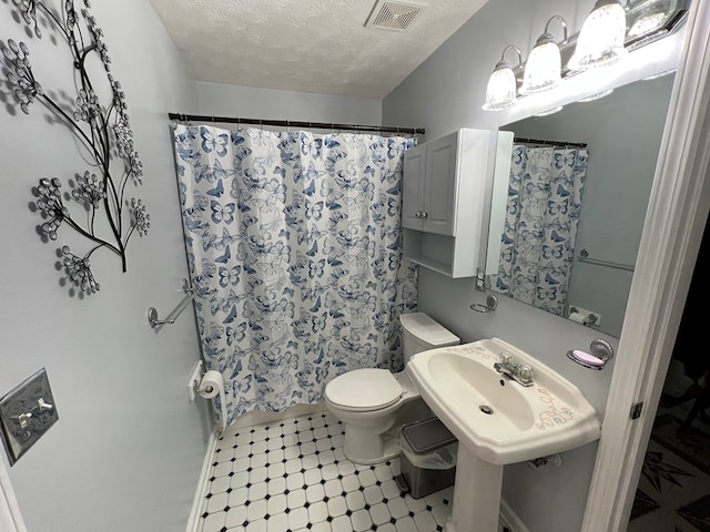 75 Briar Patch Dr, Covington, GA 30014 - bathroom with sink, a shower with curtain, tile patterned floors, a textured ceiling, and toilet