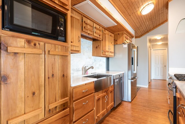 330 Ravens Gap Rd, Murphy, NC 28906 - kitchen with appliances with stainless steel finishes, light countertops, backsplash, brown cabinets, and vaulted ceiling