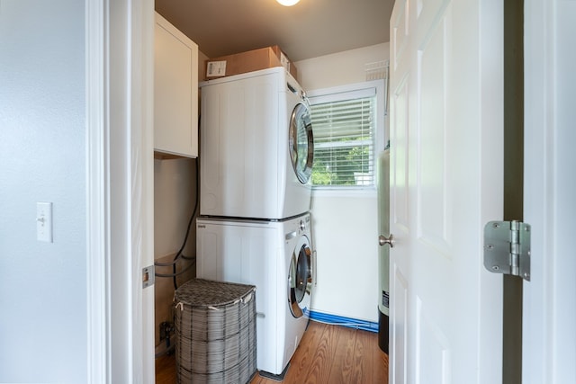 330 Ravens Gap Rd, Murphy, NC 28906 - laundry area featuring stacked washing machine and dryer, light wood-type flooring, and cabinet space