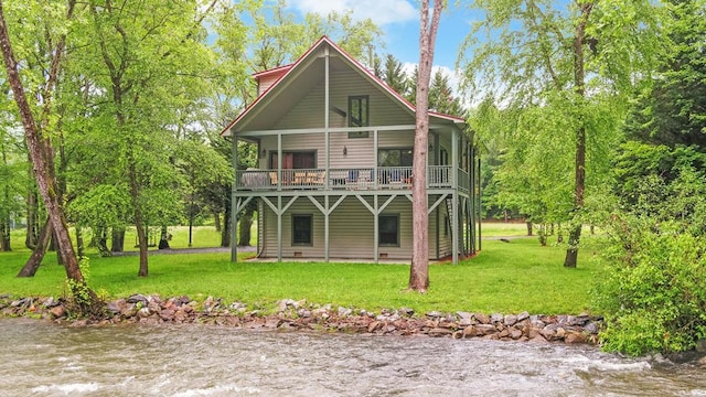 view of front facade featuring a front yard and a deck with water view