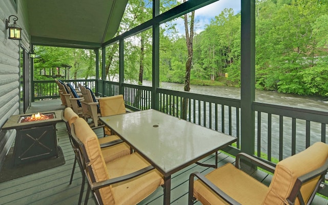 sunroom featuring a fire pit and outdoor dining area