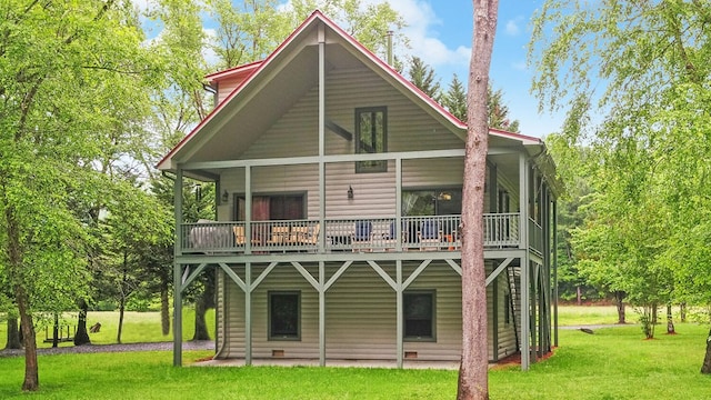 back of property featuring a lawn, a deck, and a patio