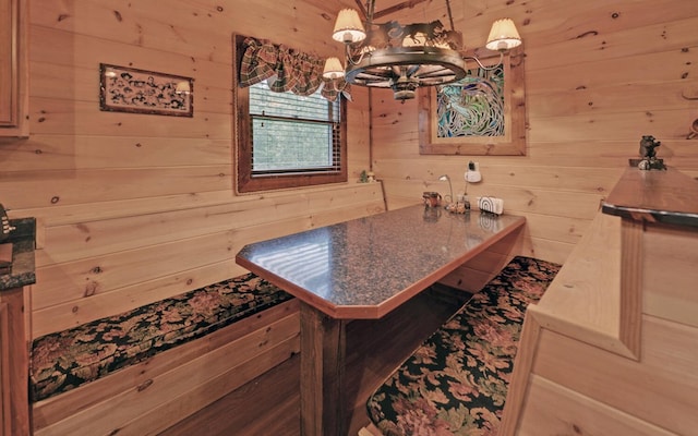 kitchen with a chandelier and wooden walls