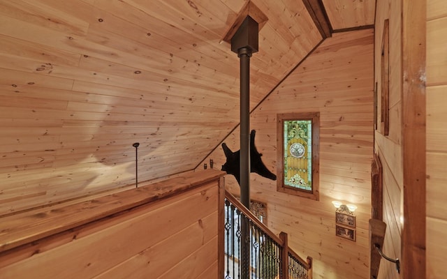 staircase with wood walls, wooden ceiling, and lofted ceiling