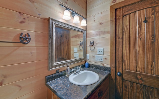 bathroom featuring wooden walls and vanity