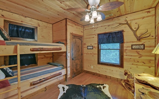 bedroom featuring wooden ceiling, wood walls, and wood finished floors