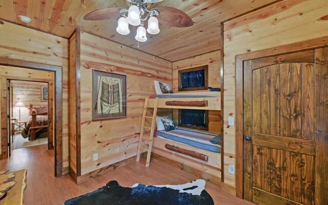 bedroom with wood ceiling, wooden walls, and wood finished floors