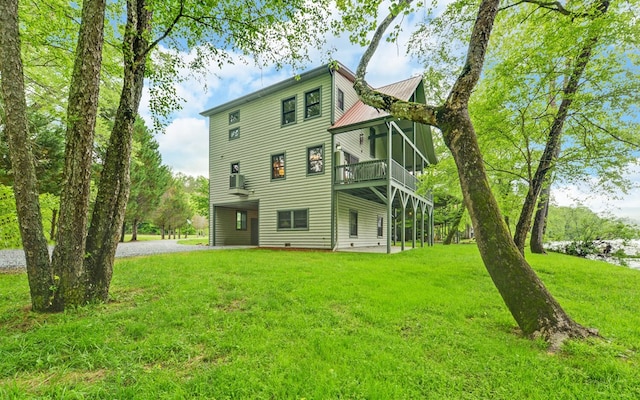 rear view of house with a lawn, a wooden deck, metal roof, and gravel driveway
