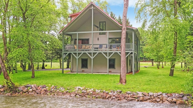 back of house featuring a yard and a deck with water view