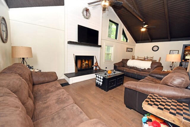 living room featuring a fireplace, wood ceiling, wood-type flooring, ceiling fan, and lofted ceiling with beams