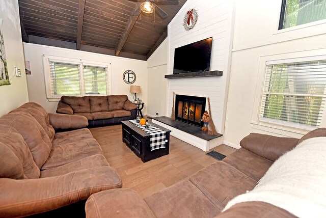 living room featuring a large fireplace, wood-type flooring, and a wealth of natural light