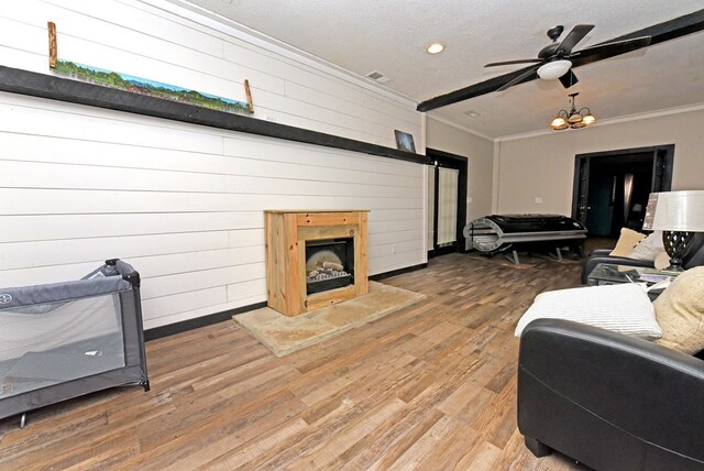 bedroom with a textured ceiling, crown molding, ceiling fan, and hardwood / wood-style flooring