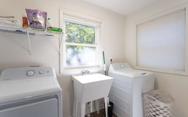 clothes washing area featuring separate washer and dryer and sink