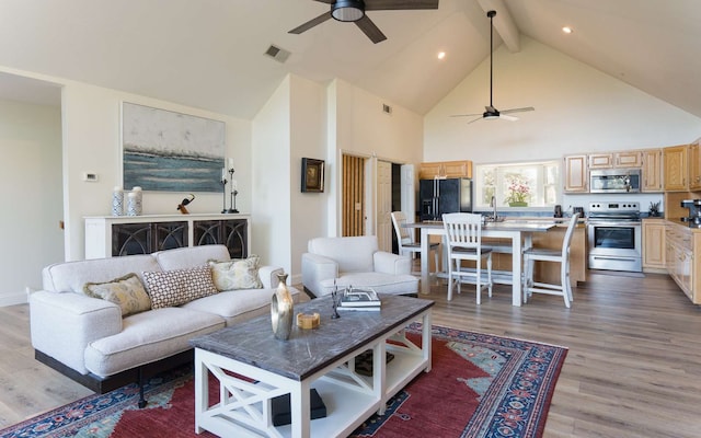 living room featuring ceiling fan, light hardwood / wood-style flooring, beamed ceiling, and high vaulted ceiling