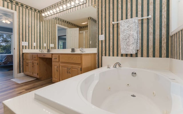 bathroom featuring a washtub, vanity, and wood-type flooring