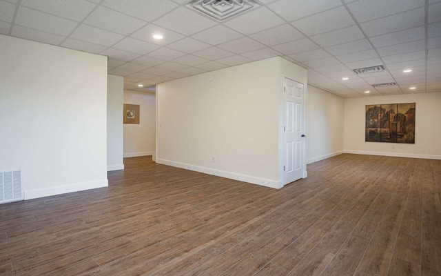 basement with a paneled ceiling and dark hardwood / wood-style flooring