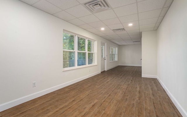 empty room featuring a paneled ceiling and wood-type flooring