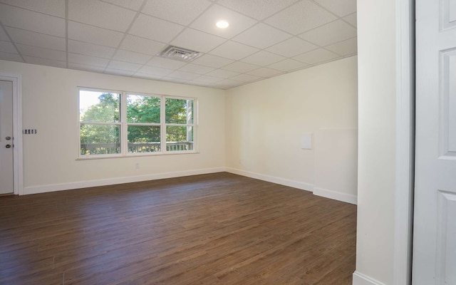 unfurnished room featuring a drop ceiling and dark wood-type flooring