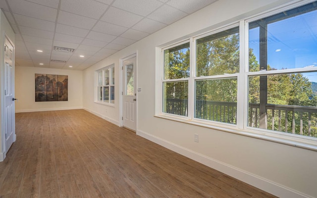 empty room featuring a paneled ceiling and wood-type flooring