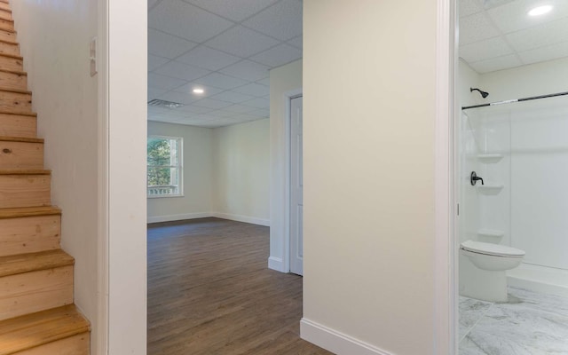 hallway featuring a paneled ceiling and hardwood / wood-style flooring