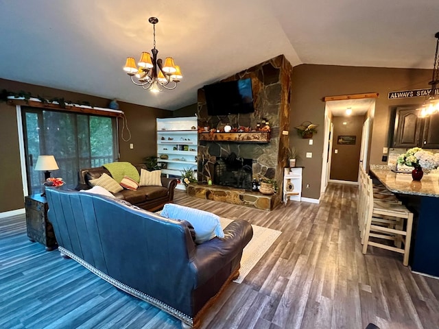 living room featuring vaulted ceiling, a stone fireplace, dark hardwood / wood-style floors, and an inviting chandelier