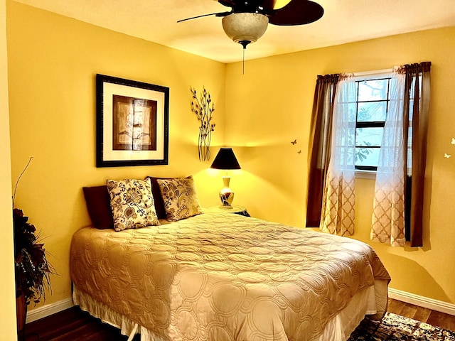 bedroom with dark hardwood / wood-style floors and ceiling fan