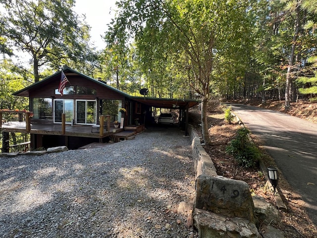 view of front of home with a wooden deck and a carport