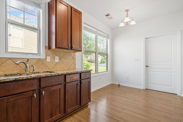 238 Balsam Dr, Canton, GA 30114 - kitchen featuring light wood-type flooring, decorative backsplash, healthy amount of natural light, and a chandelier