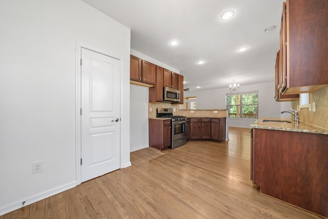 238 Balsam Dr, Canton, GA 30114 - kitchen with stainless steel appliances, light wood-style flooring, a peninsula, light stone countertops, and recessed lighting