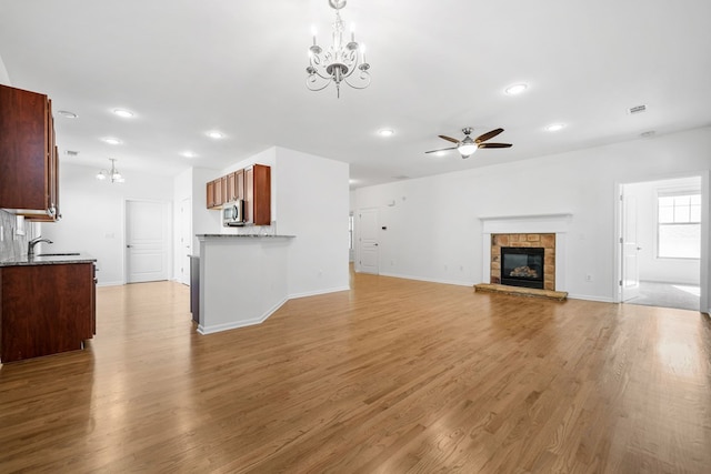 238 Balsam Dr, Canton, GA 30114 - unfurnished living room with a chandelier, ceiling fan, recessed lighting, light wood-style floors, and a stone fireplace