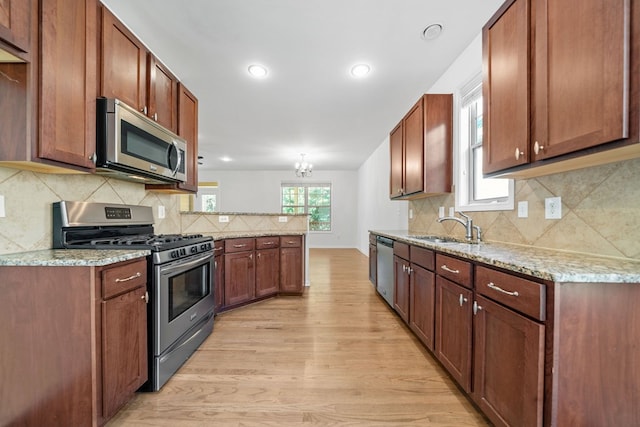 238 Balsam Dr, Canton, GA 30114 - kitchen featuring stainless steel appliances, light wood finished floors, a peninsula, a chandelier, and tasteful backsplash