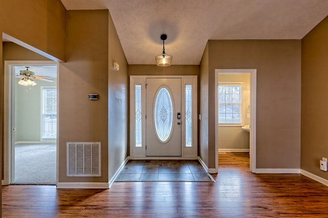 entrance foyer with dark hardwood / wood-style floors, ceiling fan, and a textured ceiling