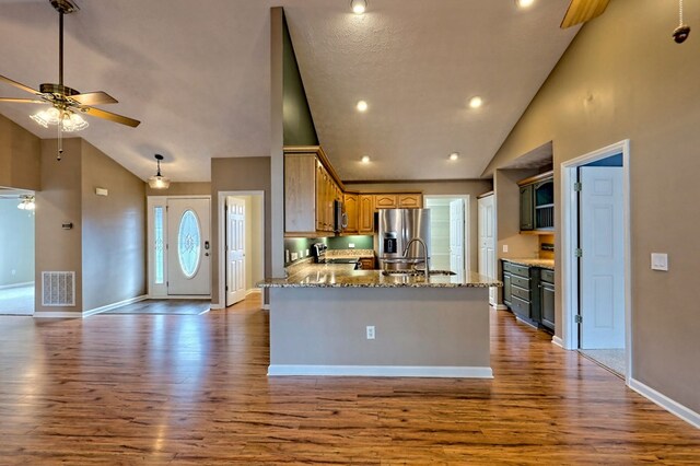 kitchen with light stone countertops, ceiling fan, hardwood / wood-style floors, and stainless steel appliances