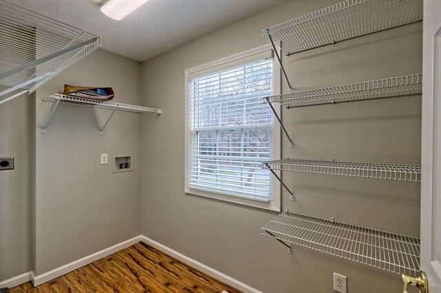 laundry room with hookup for an electric dryer, hookup for a washing machine, a textured ceiling, and hardwood / wood-style flooring