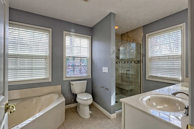 full bathroom with tile patterned floors, a textured ceiling, toilet, vanity, and shower with separate bathtub