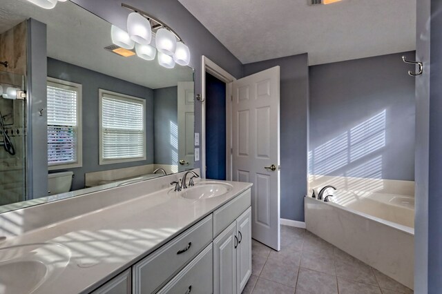 full bathroom with vanity, tile patterned flooring, toilet, a textured ceiling, and independent shower and bath