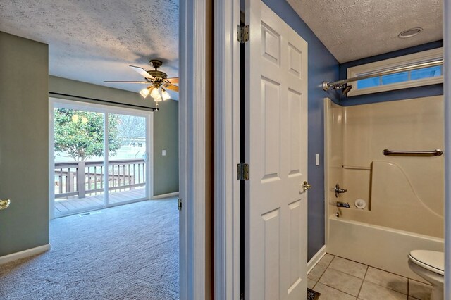 bathroom featuring ceiling fan, tile patterned floors, a textured ceiling, toilet, and shower / tub combination