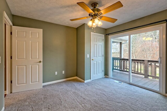 unfurnished bedroom featuring light carpet, a textured ceiling, access to outside, and ceiling fan