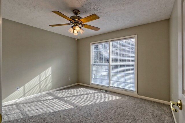 carpeted empty room with ceiling fan and a textured ceiling