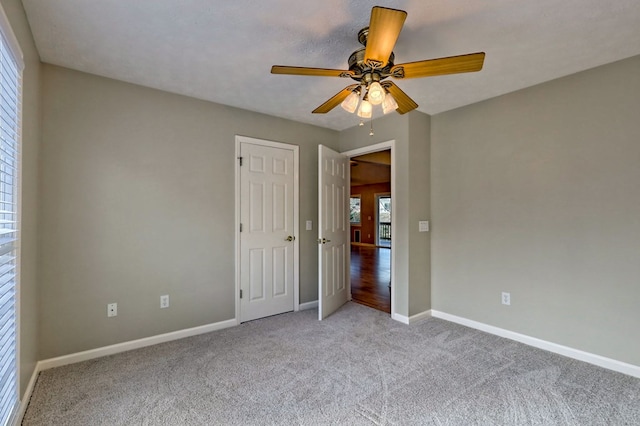 unfurnished bedroom featuring a textured ceiling, ceiling fan, and light carpet