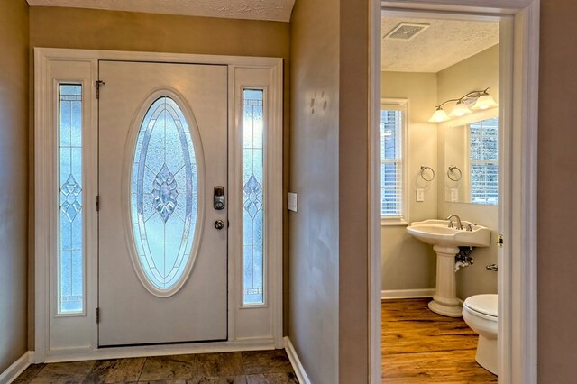 entryway featuring wood-type flooring and a textured ceiling