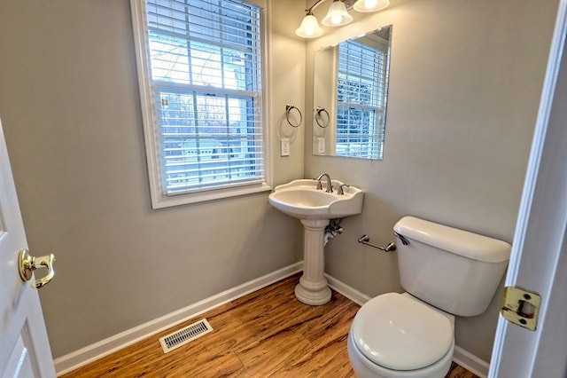 bathroom featuring wood-type flooring and toilet