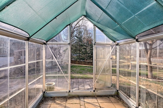 unfurnished sunroom featuring vaulted ceiling