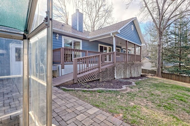 back of property with a yard and a wooden deck