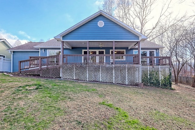 rear view of house featuring a deck, ceiling fan, and a lawn