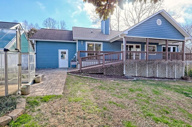 back of house with an outbuilding, a yard, and a deck