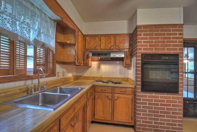 kitchen featuring backsplash, oven, white cooktop, and sink