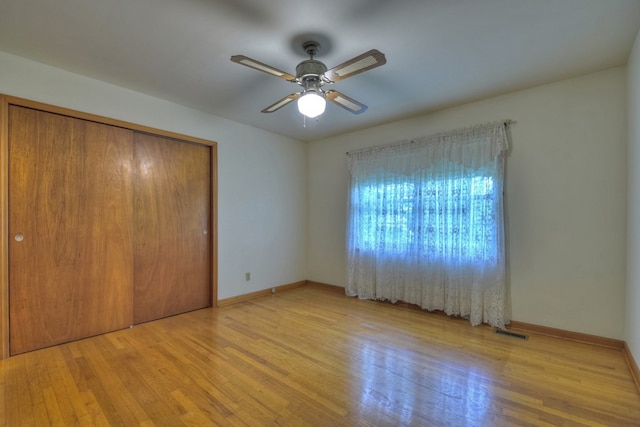 unfurnished bedroom featuring ceiling fan, light hardwood / wood-style flooring, and a closet