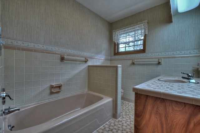 bathroom featuring vanity, tile walls, and a bathing tub